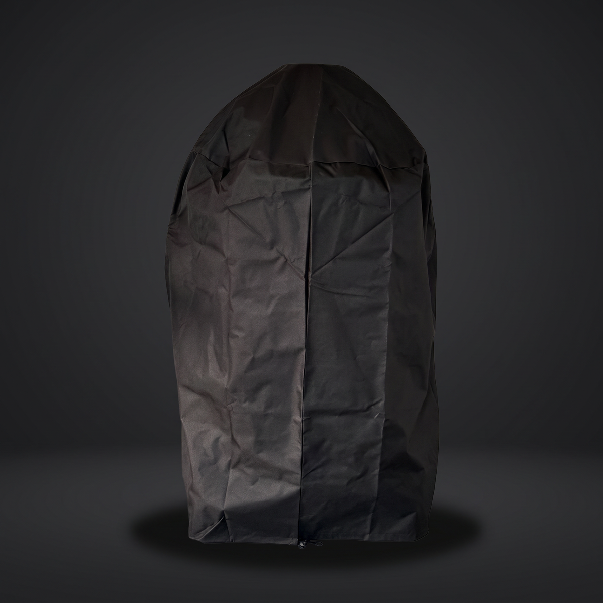 Kamado volledig overtrokken met de donkere hoes; de koepelvorm van de kamado is nog zichtbaar door de stof heen, tegen een donkere achtergrond.