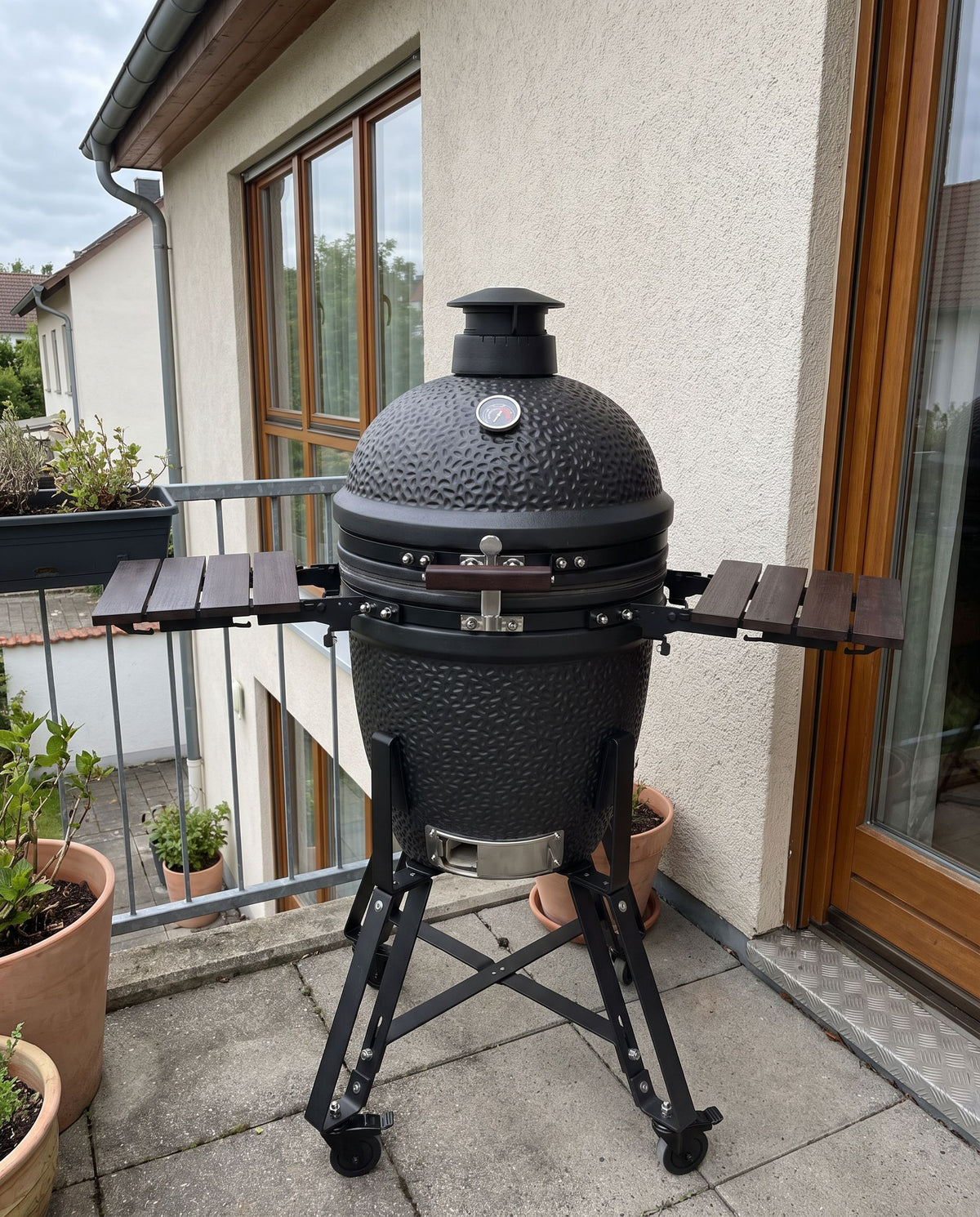 Kamado op een klein terras, geen personen.